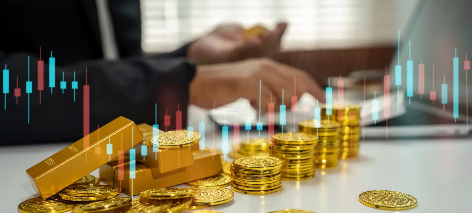 Gold bars and coins over a candlestick chart